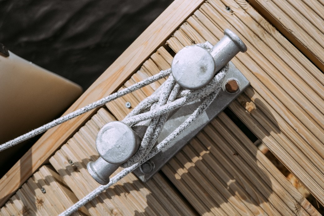 Ship Anchor With Rope Tied On Wooden Ramp